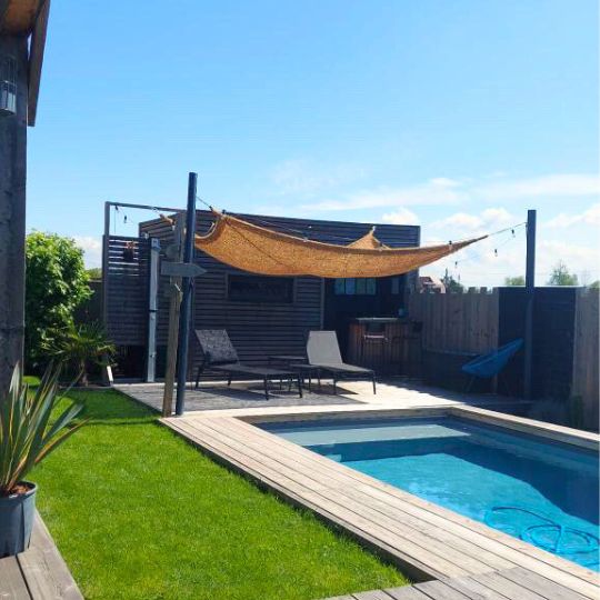 Toile en coco entre poteaux pour voile d'ombrage au bord d'une piscine