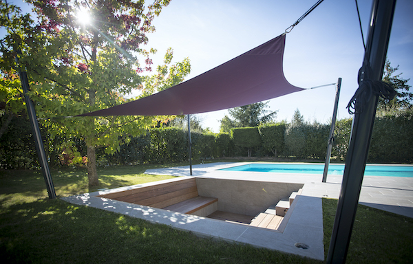 une voile d ombrage fixée sur 4 mats